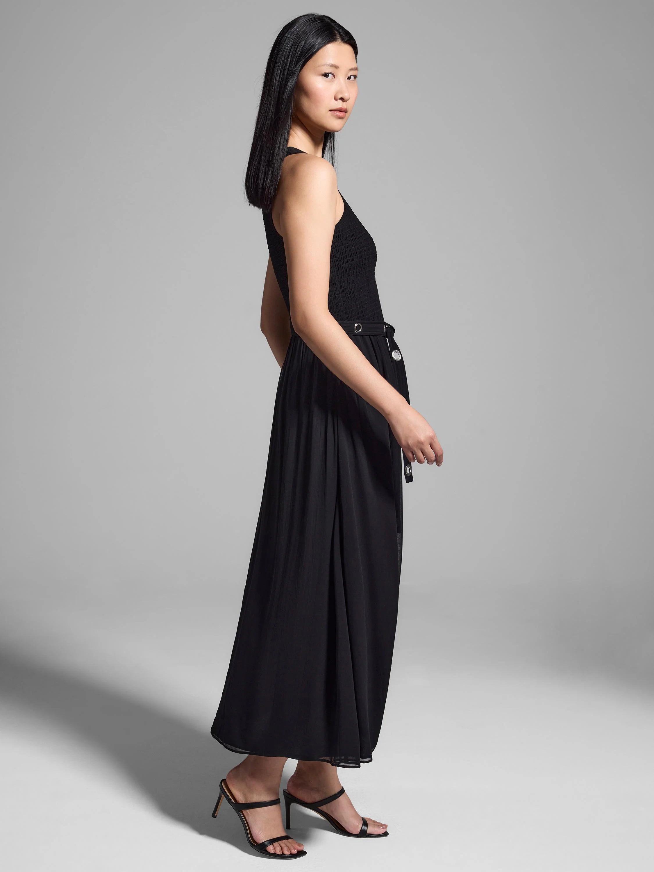 Black smocked bodice, chiffon midi skirt, silver grommets, and self-tie belt.