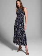 Midnight blue midi dress with an abstract print in off-white and dark blue. Halter neck, smocked bodice, and belted waist.