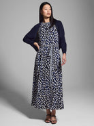 Midi dress with navy & white abstract print, belted waist, and a matching navy cardigan.