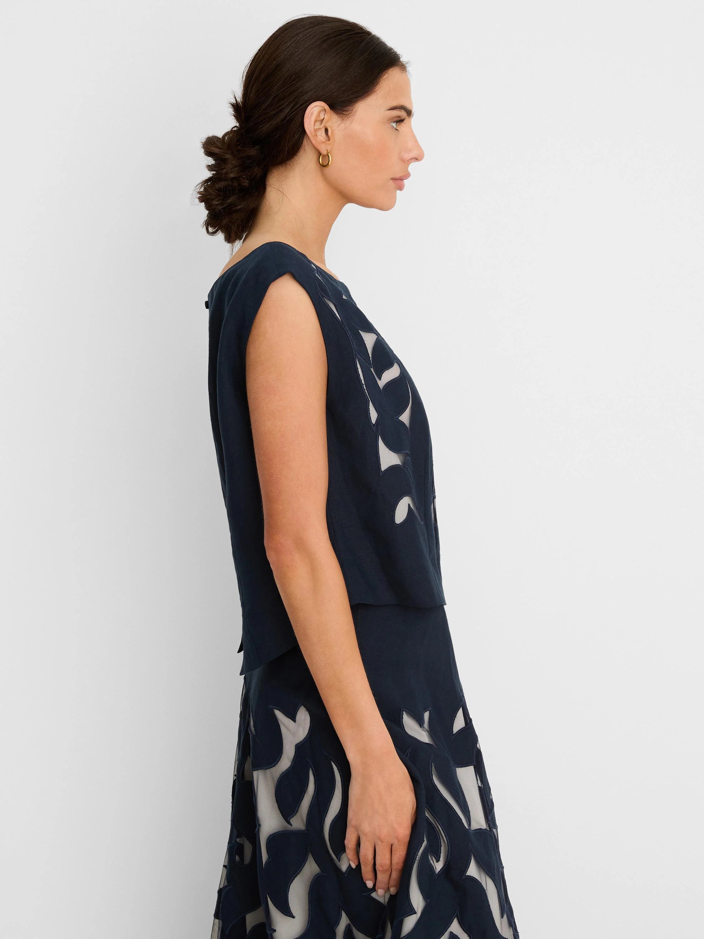 Navy linen sleeveless top with light underlayer showing through an organic cut-out pattern.