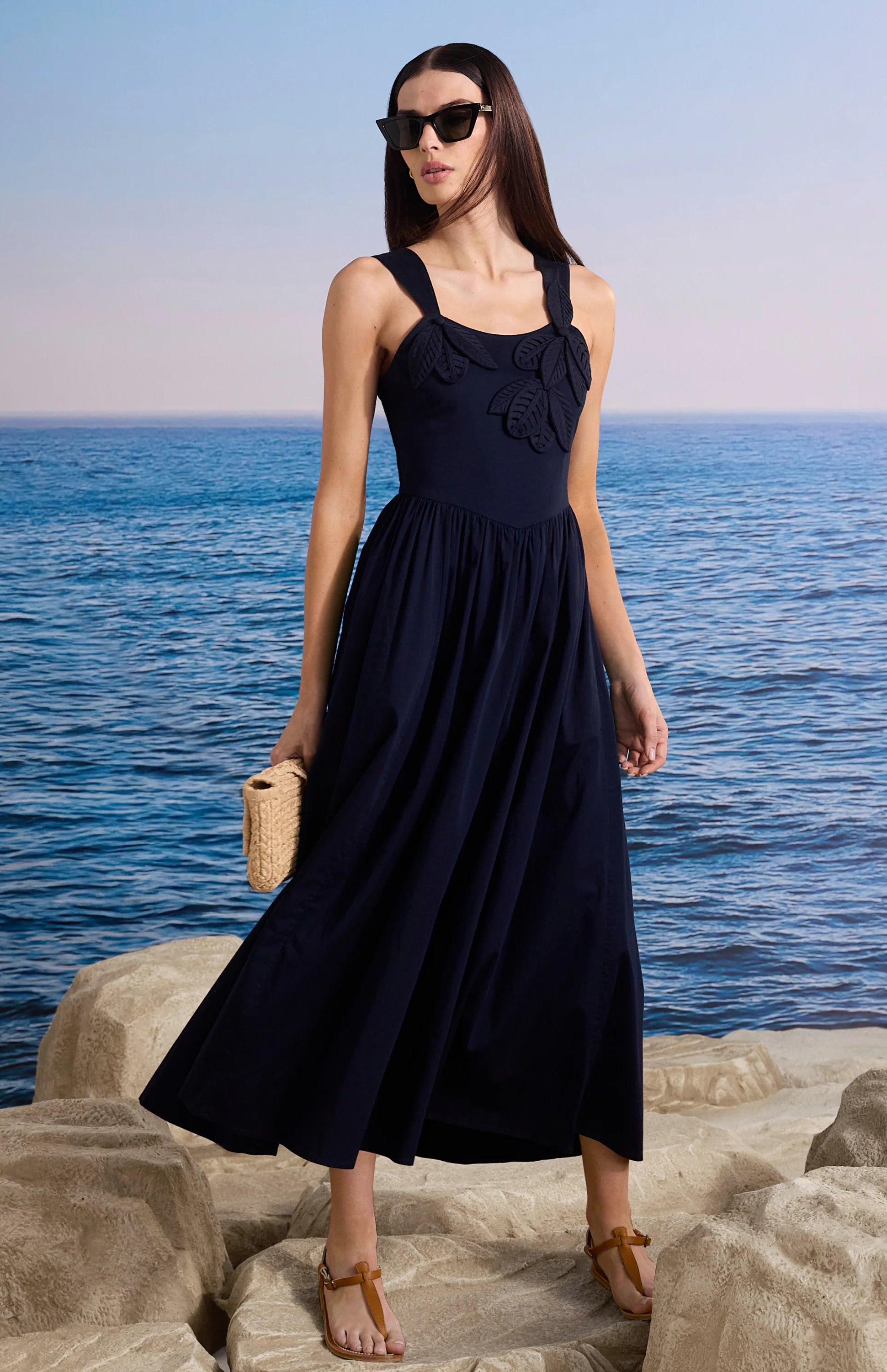 Navy midi dress with leaf design on bodice and a full, flowing skirt.