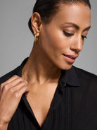 Black, drapey tencel sweater with subtle vertical pleats and a collared neckline.