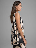 Black sleeveless top with beige floral print, pleated hem.