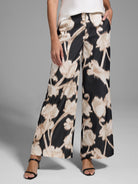 Wide-leg pants; black background with beige floral pattern.