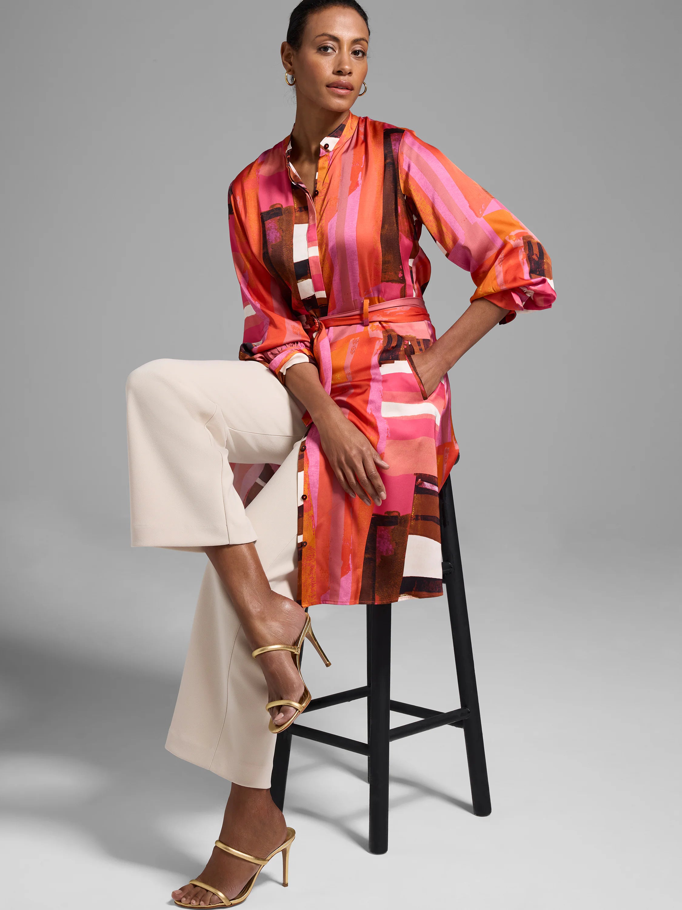 Long, belted shirtdress in glossy pink, orange, brown, and white abstract print.