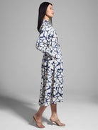 Off-white midi shirt dress with a navy blue and white fractured line pattern, long sleeves, and a belted waist.