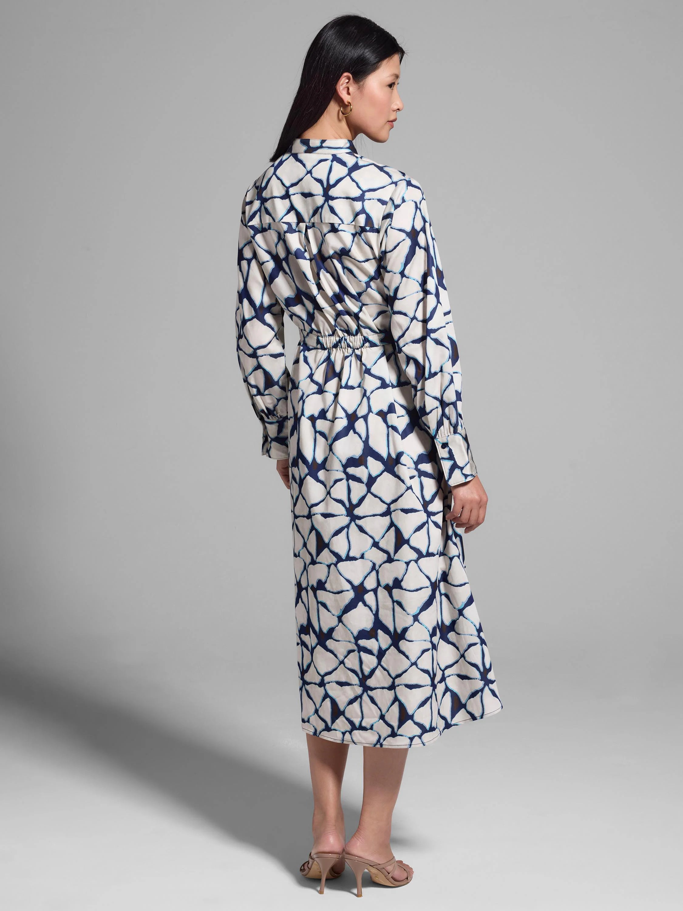 Off-white midi shirt dress with navy blue and light blue fractured line pattern, cinched waist.