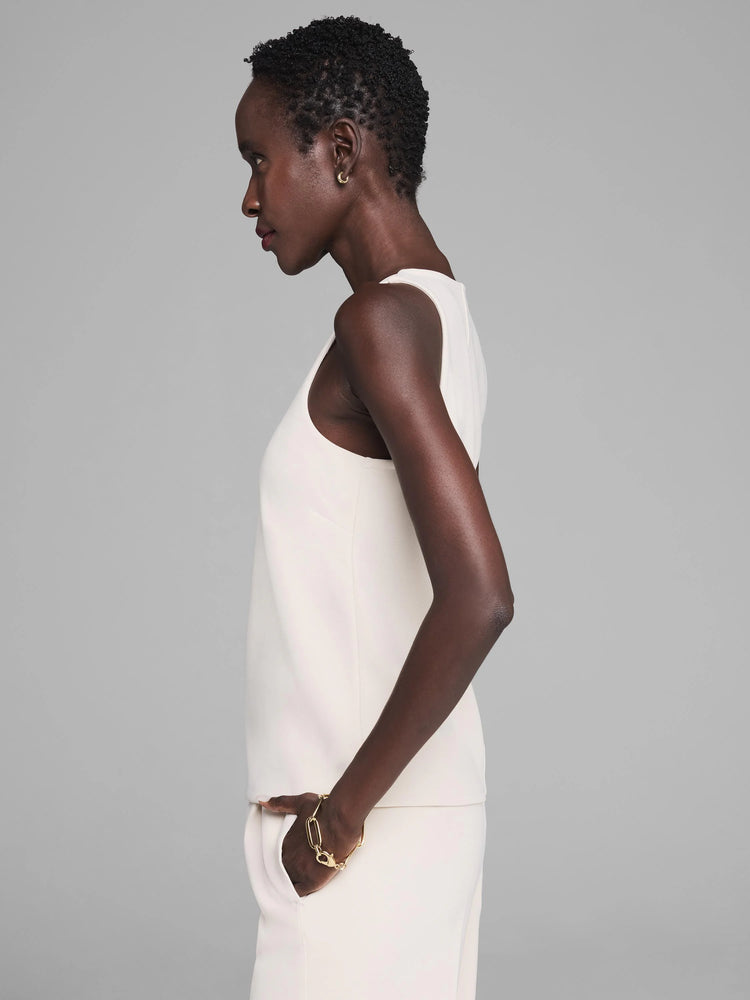 Off-white knit scuba V-neck tank. Smooth, structured fabric, worn by a model in side profile.