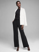 Black sleeveless jersey tank with extensive draping across the bodice and waist.