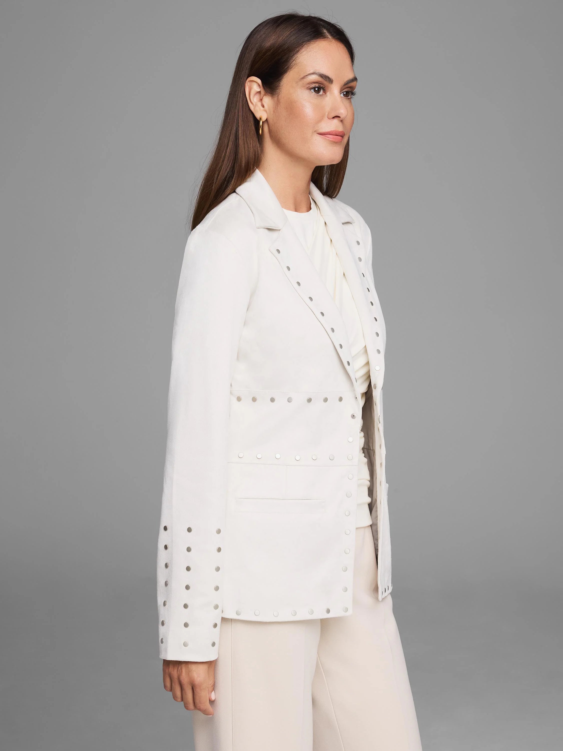 Off-white blazer with silver studs along the front, cuffs, and hem.  The blazer is shown on a model.