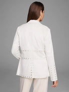 Off-white blazer with silver studs along the seams and cuffs.  Rear view.