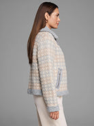 Beige & light grey houndstooth knit jacket with fuzzy grey collar, cuffs, hem, and a zippered pocket.