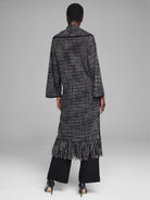 Long black & white tweed jacket with wide sleeves and a full fringe hem, shown from the back.
