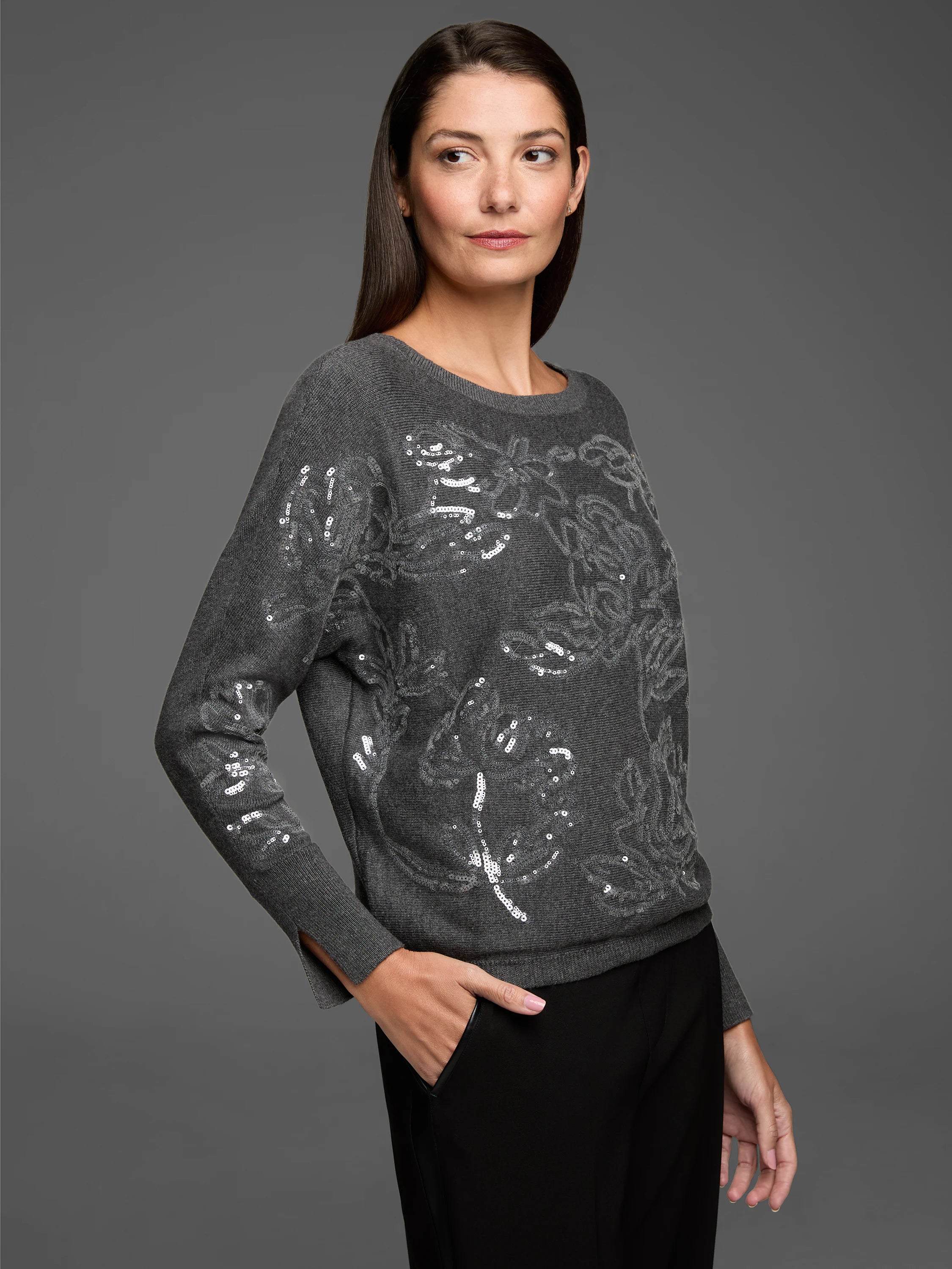 Dark gray sweater with a round neck and long sleeves, featuring a floral design made of silver sequins.