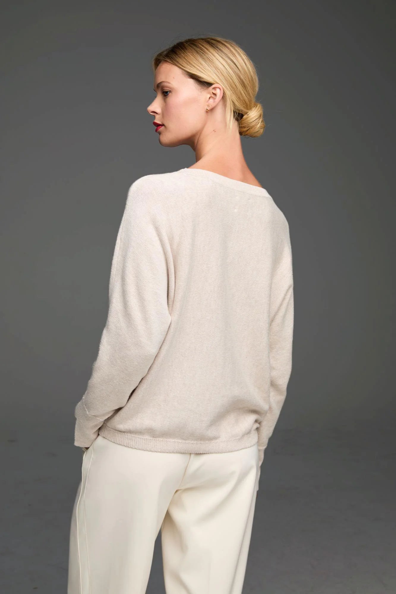 Light beige long-sleeve sweater. Features a relaxed fit, wide neckline, and ribbed cuffs and hem.