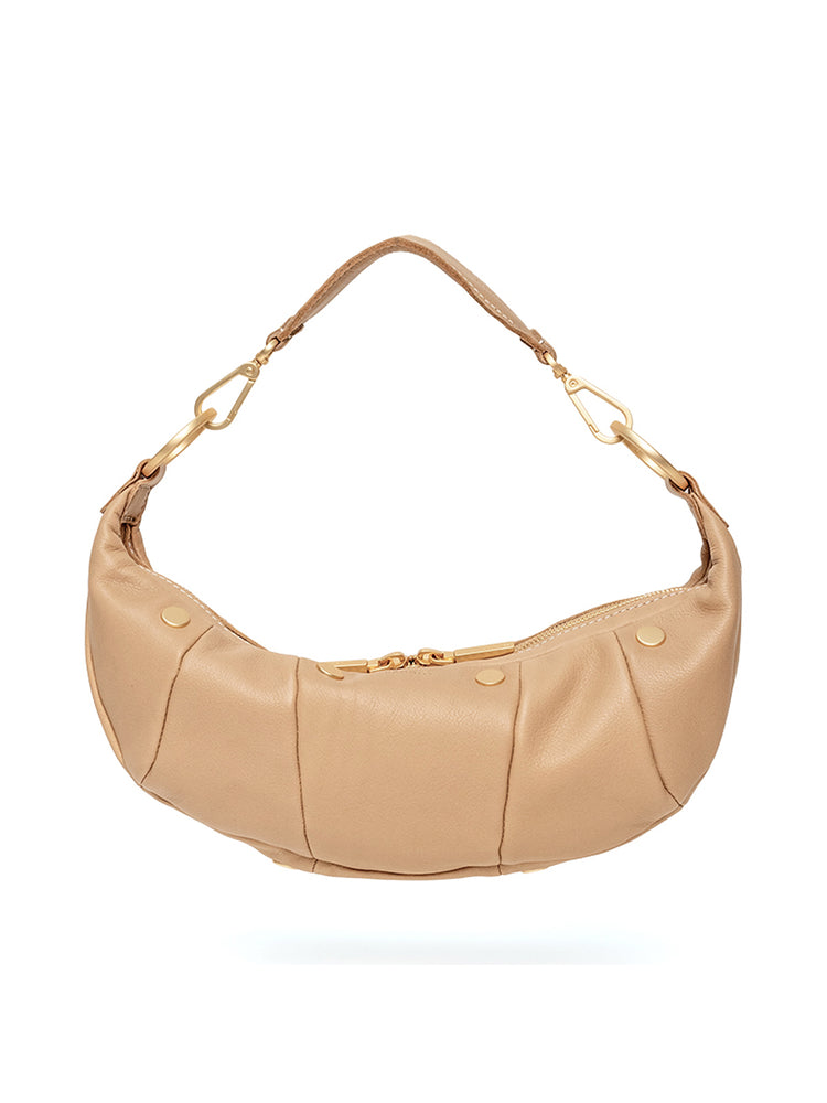 Light tan leather croissant shoulder bag featuring padded vertical panels and gold zipper hardware.