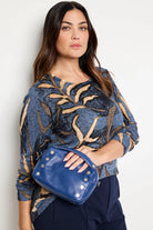 Small royal blue pebbled leather crossbody bag with silver studs and a top handle.