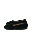Black velvet flat slippers with round toes and thin brown soles.