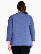 Dusty blue knit blazer, three-quarter sleeves, fringed edges.  Textured fabric with visible knit pattern. Rear view.