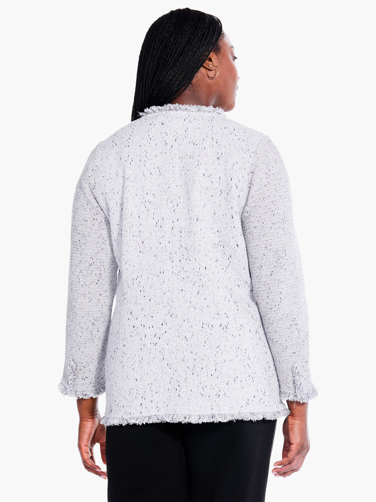 Gray knit blazer with black flecks, fringe trim at cuffs and hem. Three-quarter sleeves.