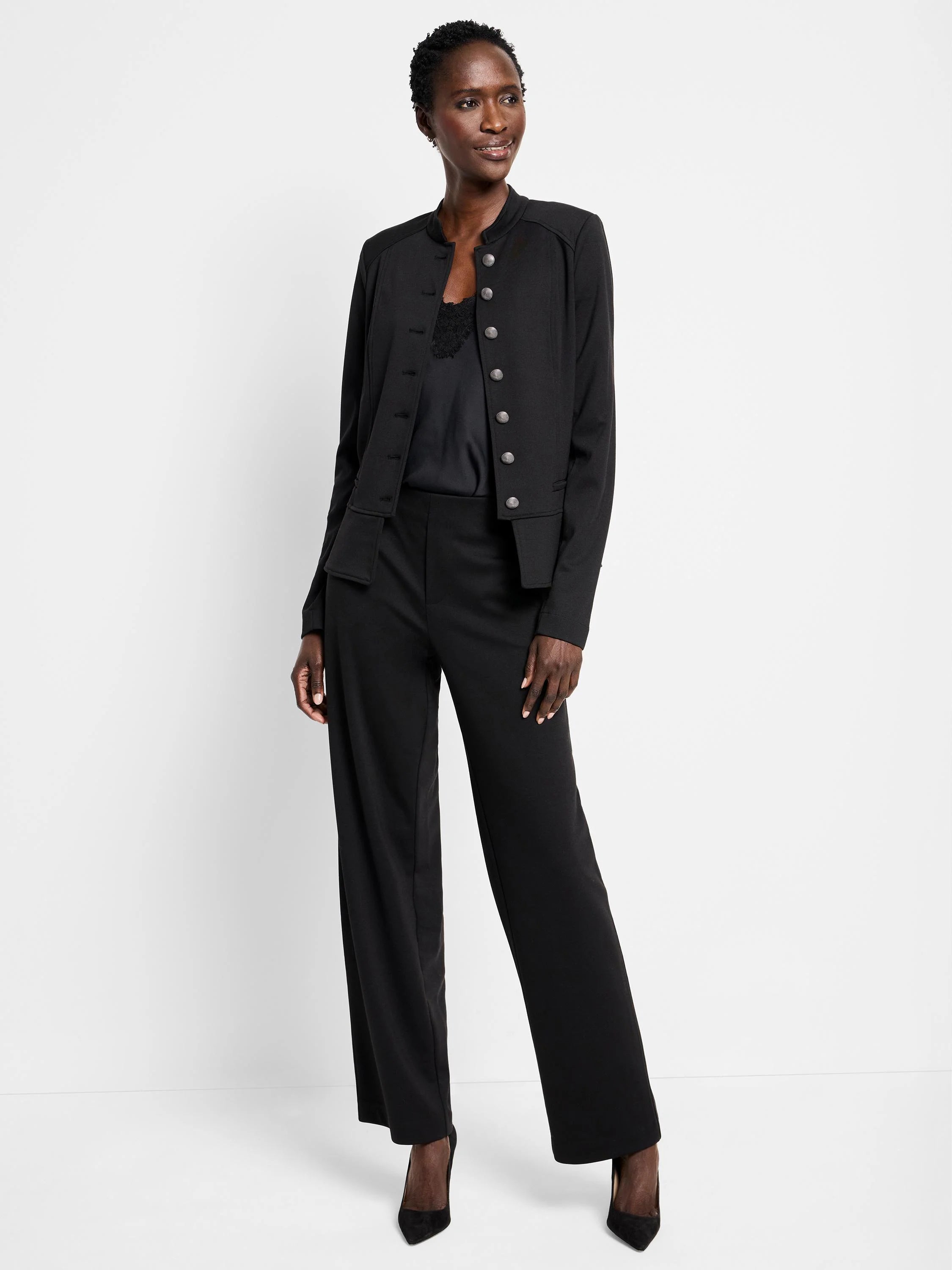 Black knit jacket with a band collar and a double row of silver buttons. Hip-length.