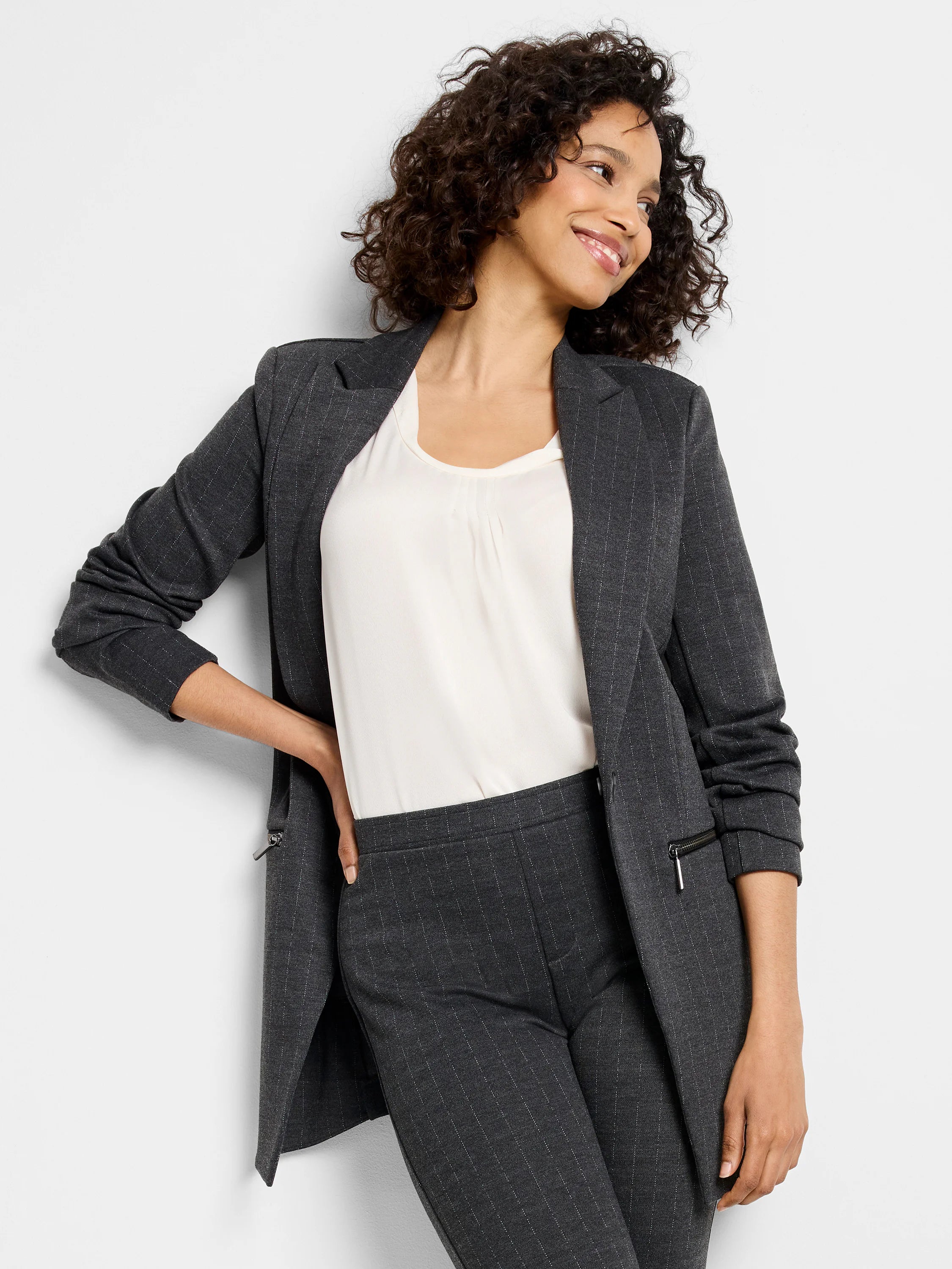 Charcoal knit zip jacket with fine white pinstripes. Open front with notched lapels and hip zippers.