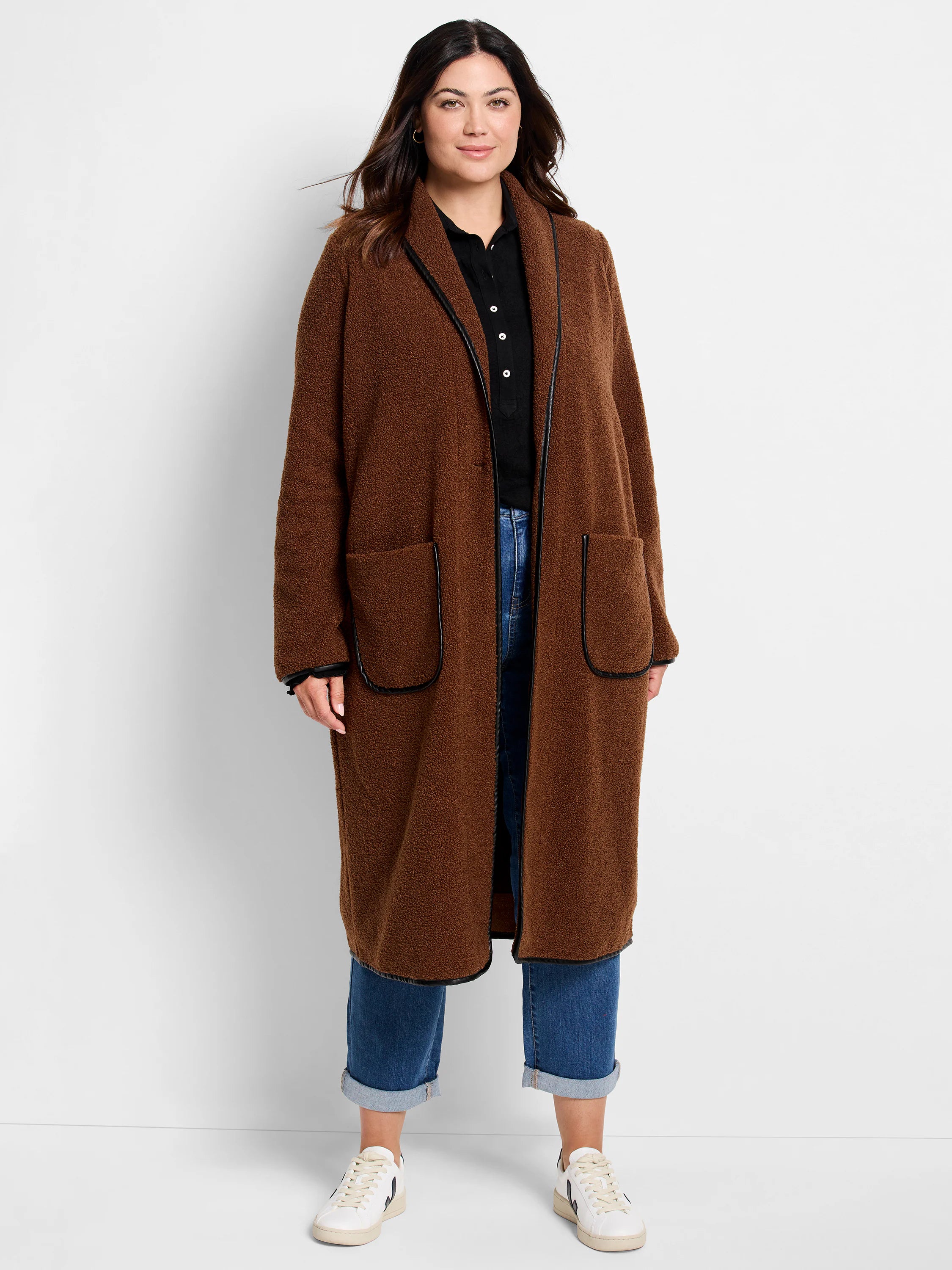 Long brown teddy coat with black trim on lapels, down the front opening, and around patch pockets.