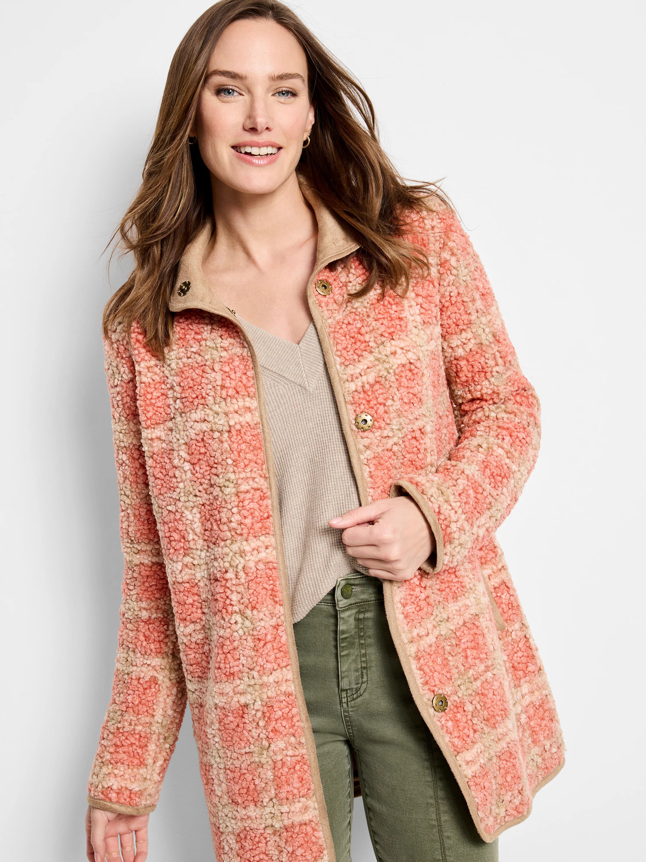 Sherpa jacket with peach and beige plaid pattern, tan trim, and snap buttons.