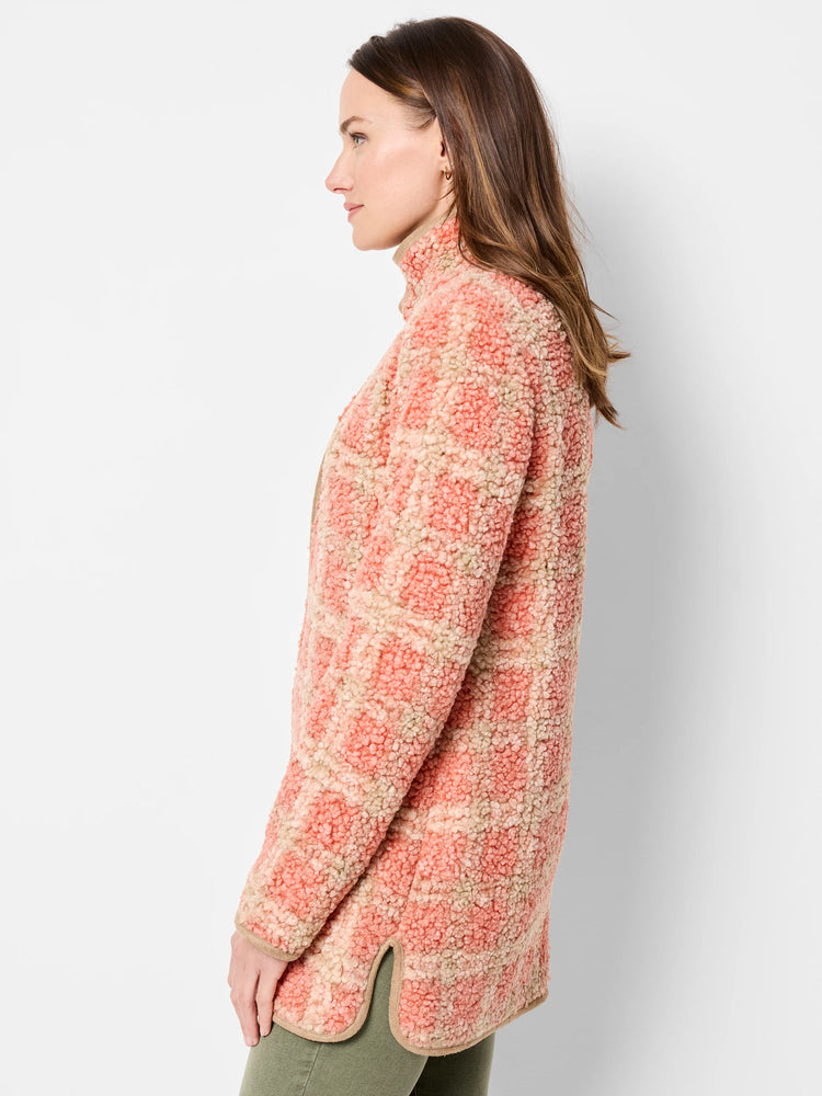 Woman in profile wearing a pink and beige plaid sherpa jacket. Features a high collar, tan trim, and rounded side slits.