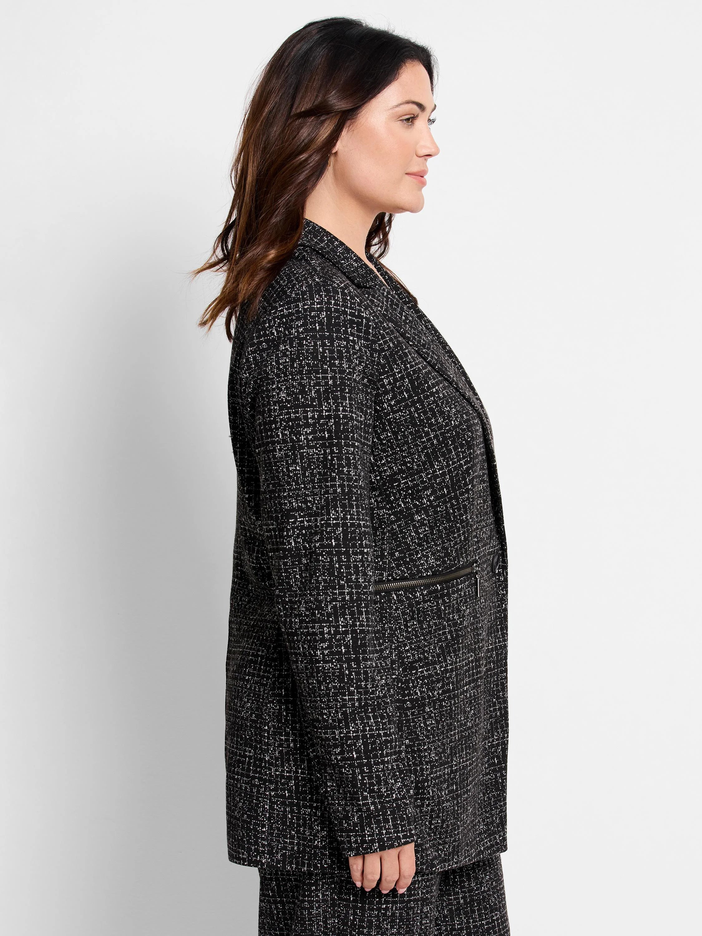 Black knit jacket with white dotty grid pattern and a horizontal zipper detail.
