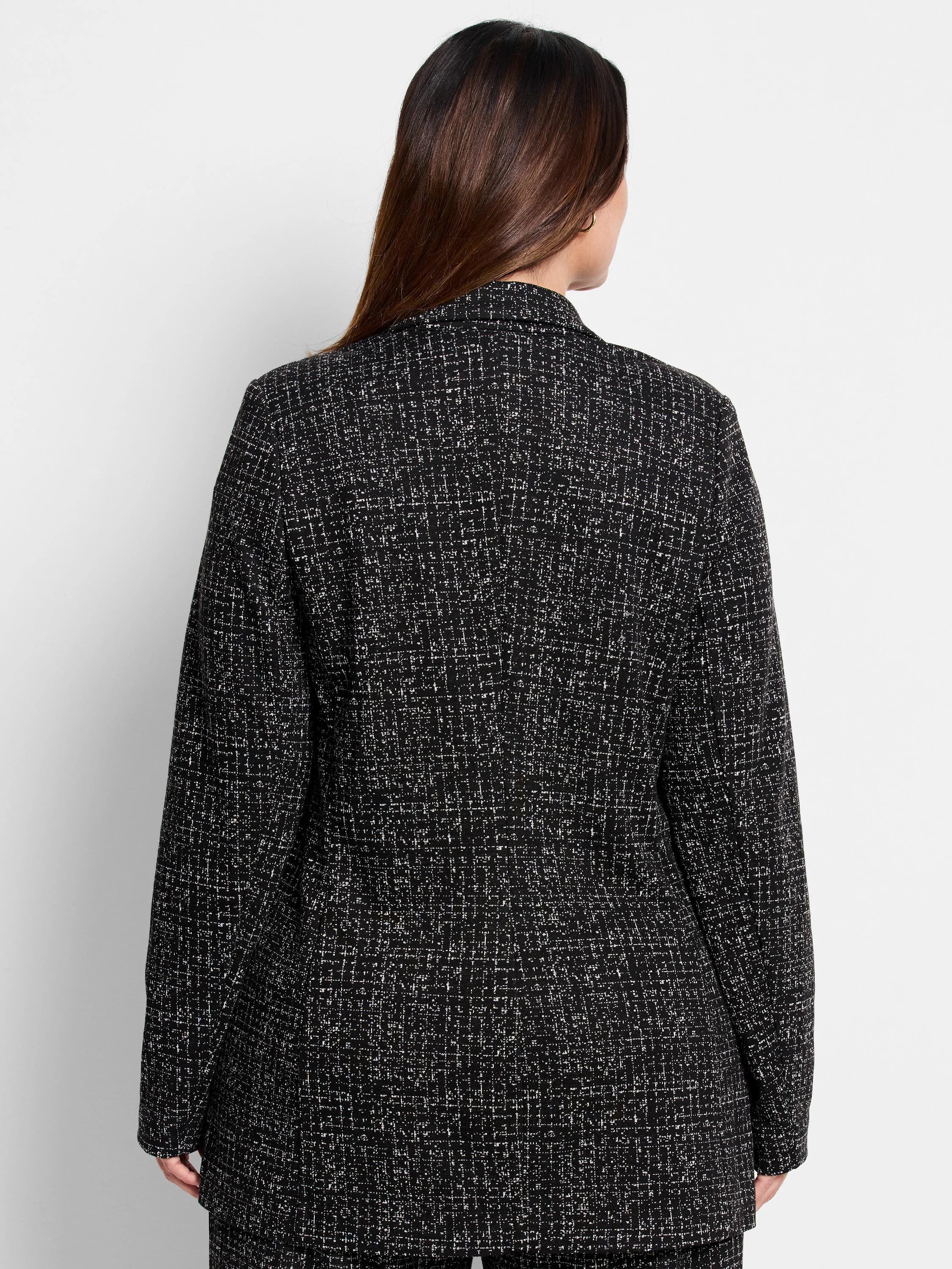Black knit jacket with a white dotty grid pattern, shown from the back.