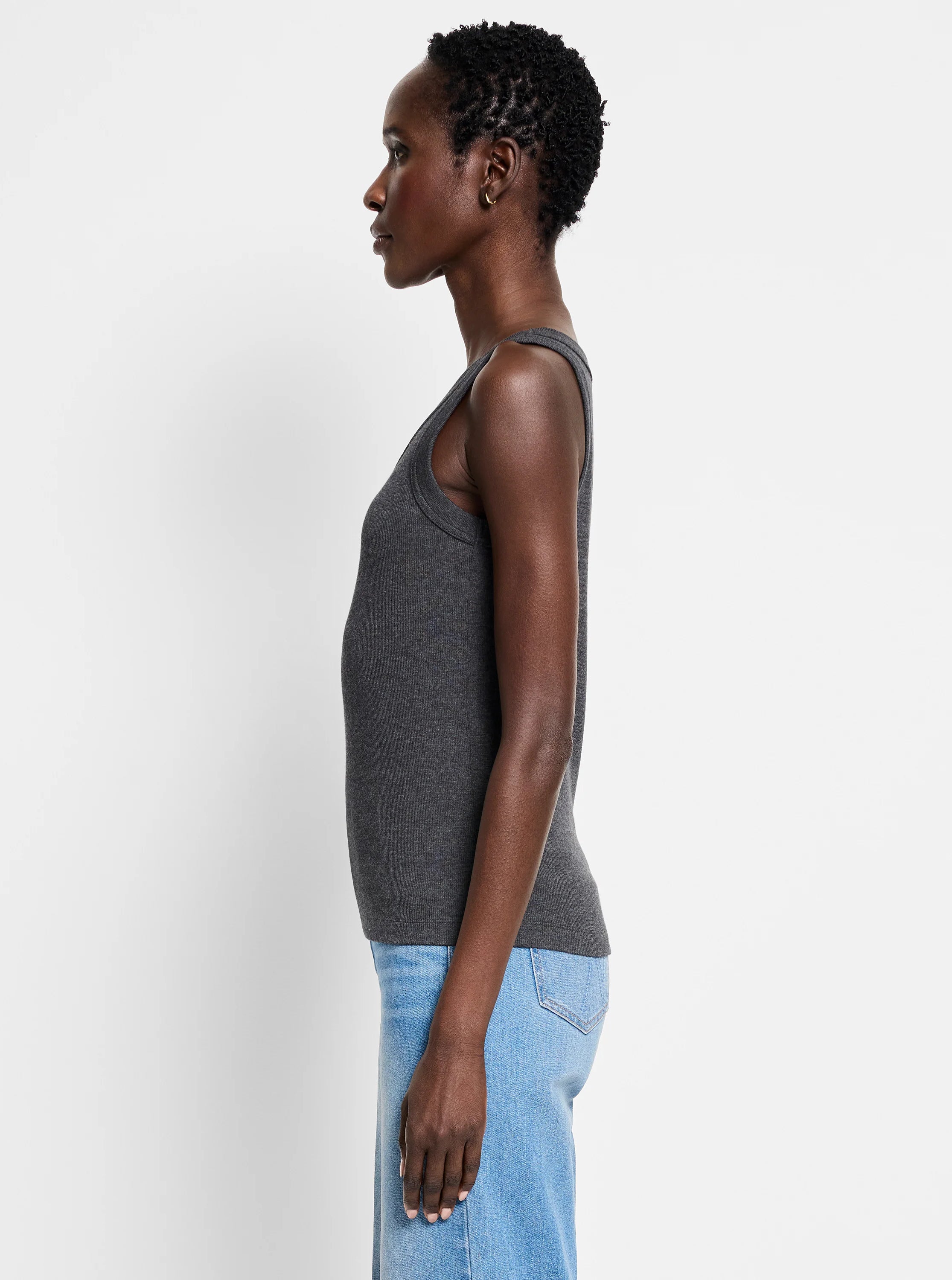 Fitted dark gray ribbed knit scoop tank. Model shown from side.