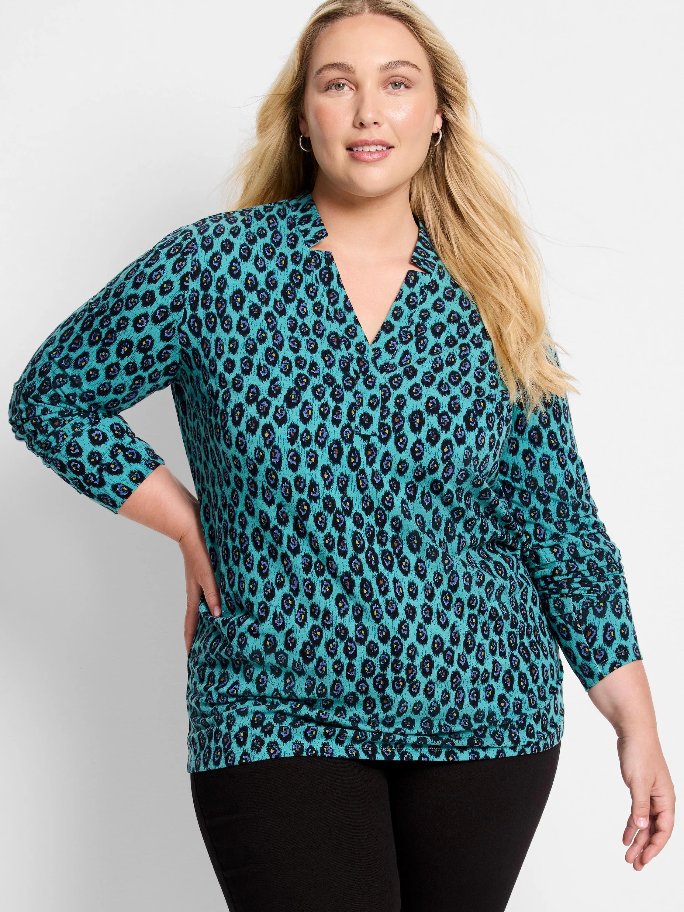 Teal leopard print top with black, blue, and yellow spots. Features a notched V-neck and long ruched sleeves.