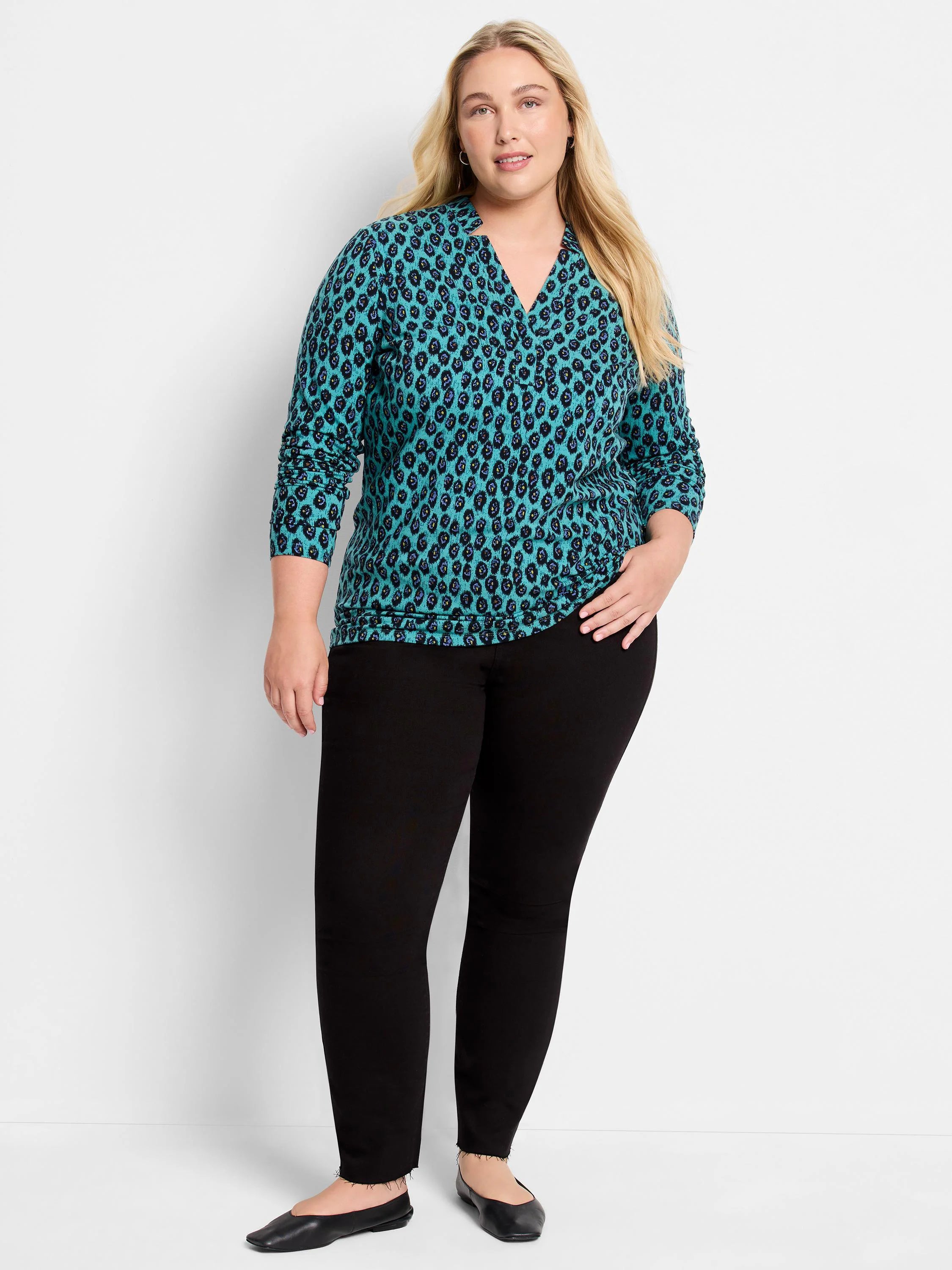 Teal long-sleeved top with a notched V-neck and an all-over black and blue irregular pebble pattern.