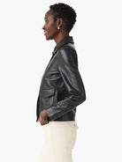 Black faux leather jacket with a pointed collar, front flap pockets, and a banded waist hem.