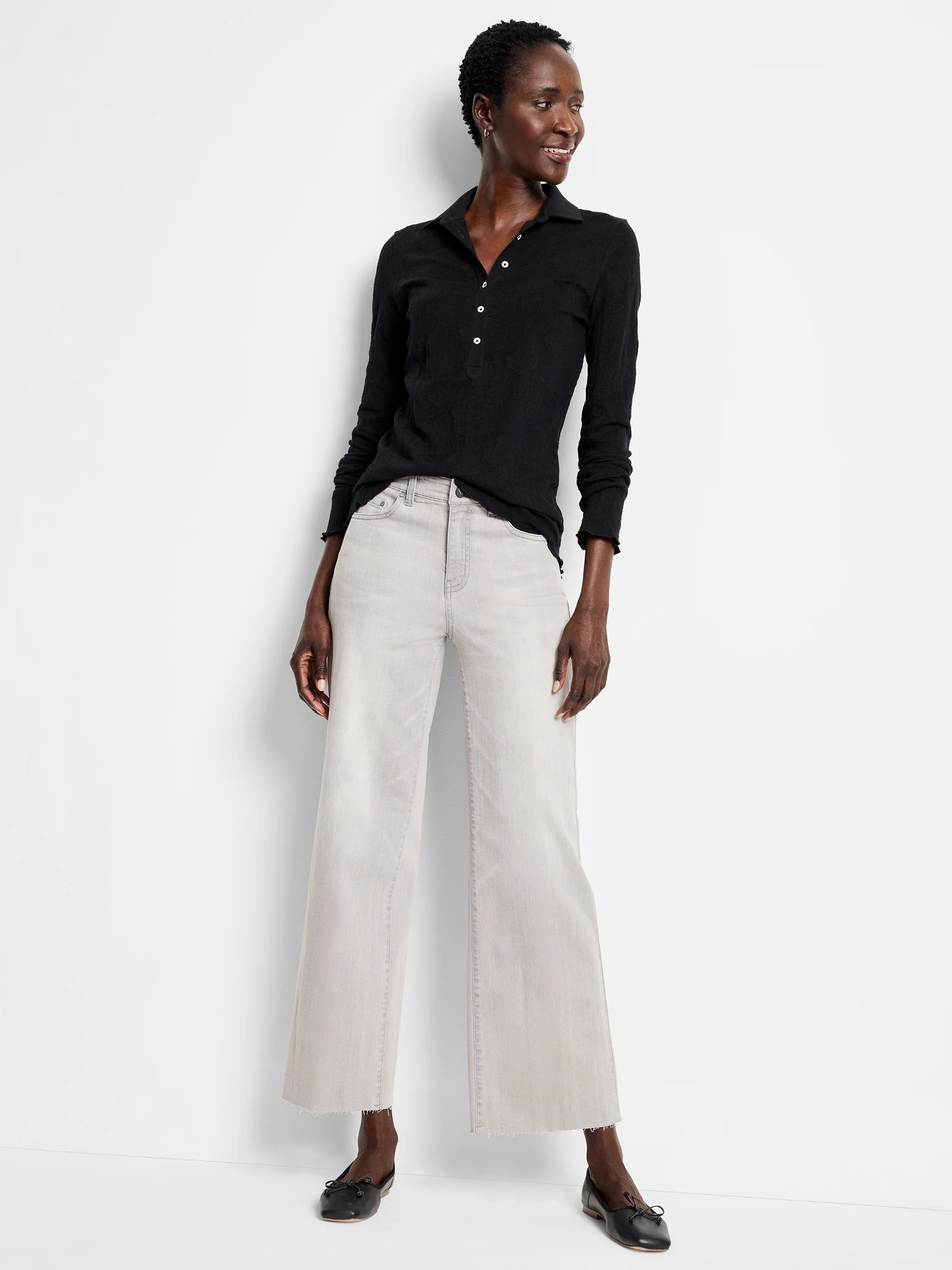 Black lace knit collared top with white buttons, long sleeves, and ruffled cuffs.