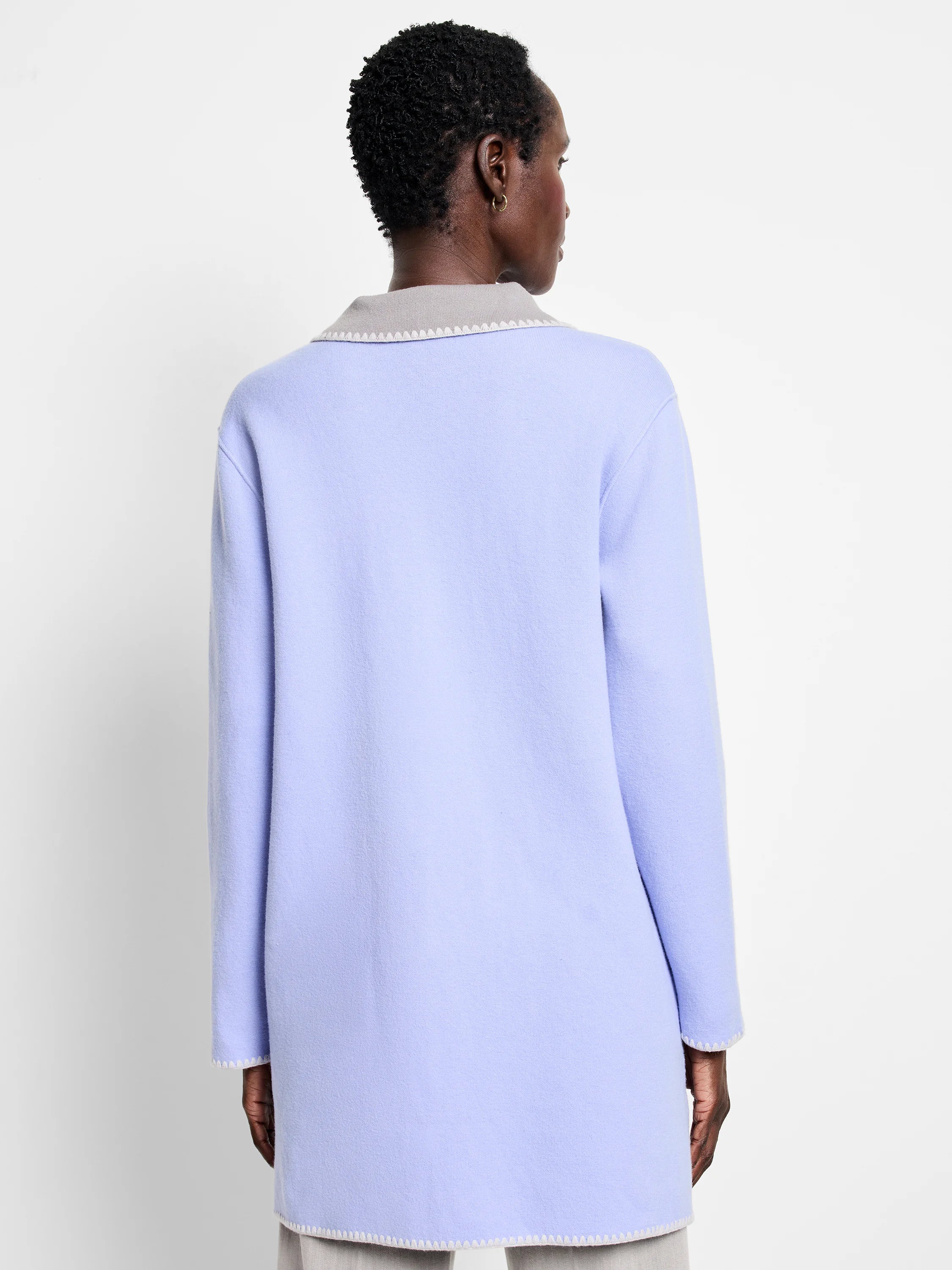 Lavender knit jacket with light grey reversible lining. Cream zig-zag stitching details collar, cuffs, and hem.