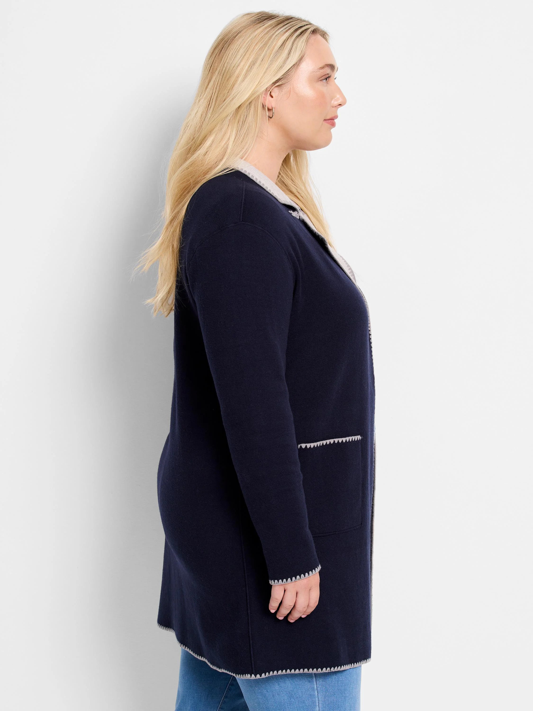 Navy reversible knit jacket with light grey scalloped trim on collar, cuffs, hem, and pockets.
