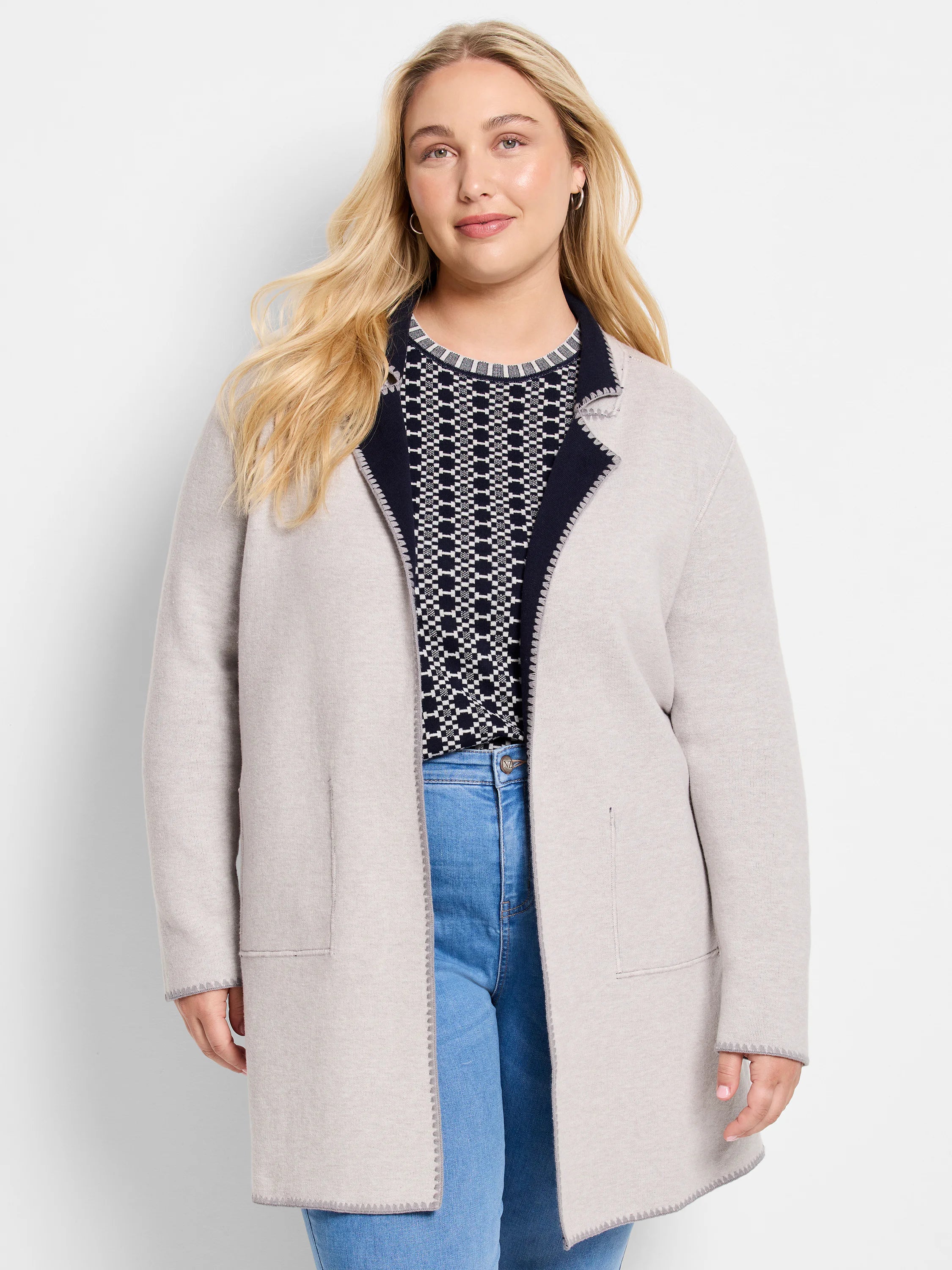 Light beige reversible knit jacket with navy interior trim. Features gray edge stitching and front pockets.