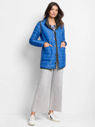 Bright blue quilted puffer jacket with olive green trim, gold snap buttons, and front patch pockets.