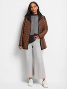 Brown reversible quilted puffer jacket with black trim and gold snap buttons.