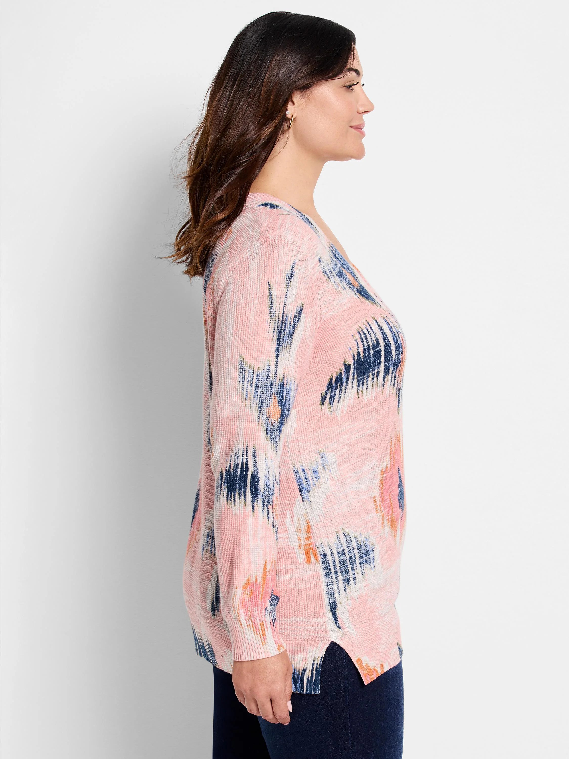Pink waffle-stitch V-neck sweater with abstract patterns of navy, light blue, and orange brushstrokes.