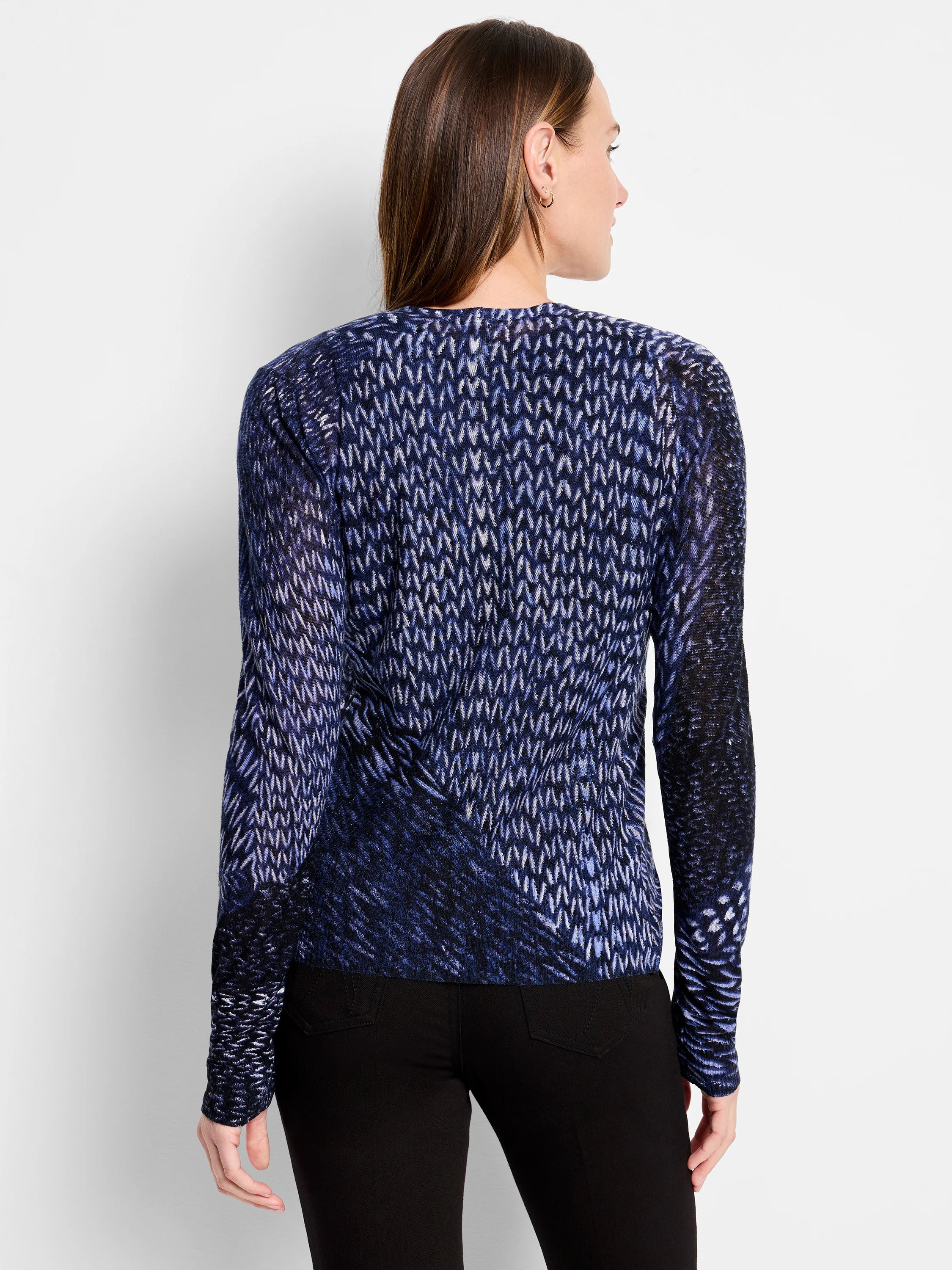 Back of indigo cardigan with a knit pattern of white and light blue dashes on a dark blue background. Long-sleeved.