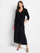 Black knit jacket with fringe trim, 3/4 sleeves, and two front patch pockets with silver buttons.