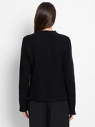 Black textured knit jacket, back view, with fringe details at the neckline, hem, and cuffs.