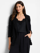 Black knit jacket featuring fringe trim along the lapels, shoulders, and cuffs.
