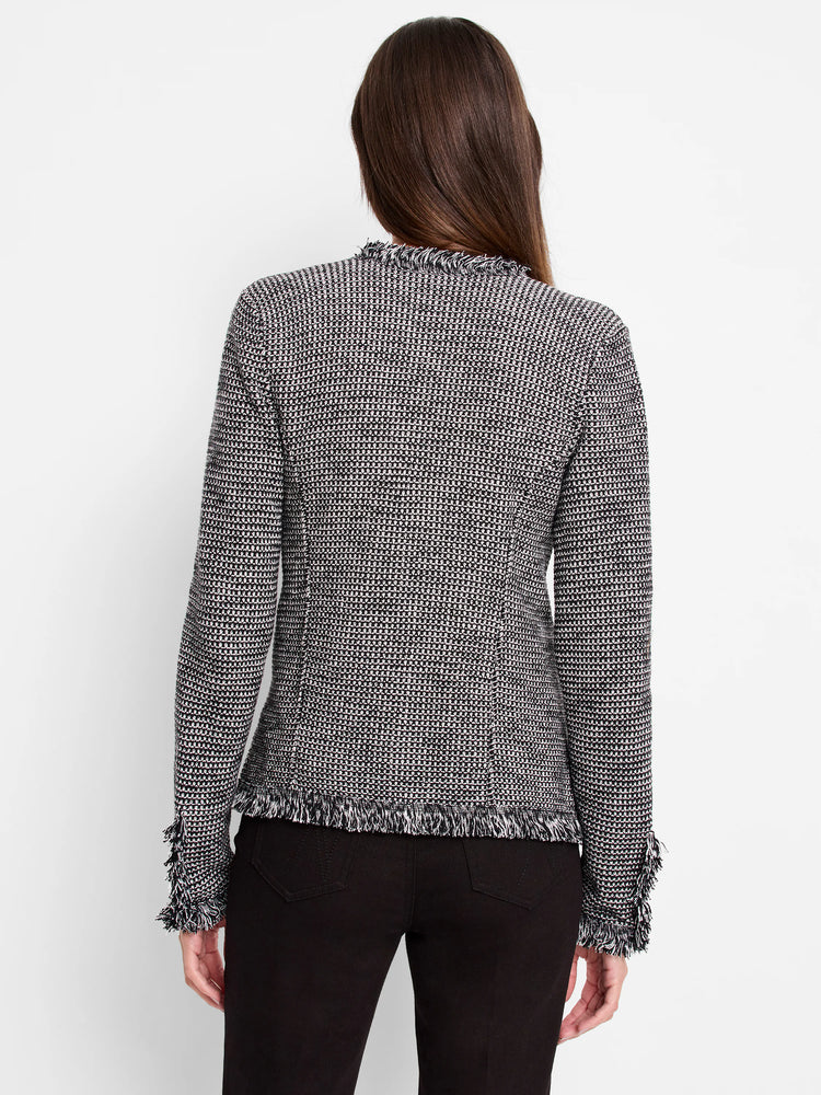 Black and white geometric knit jacket, seen from back. Features fringe along the neckline, hem, and cuffs.