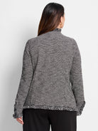 Black and white patterned knit jacket with a mock neck, fringed collar, cuffs, and hem.