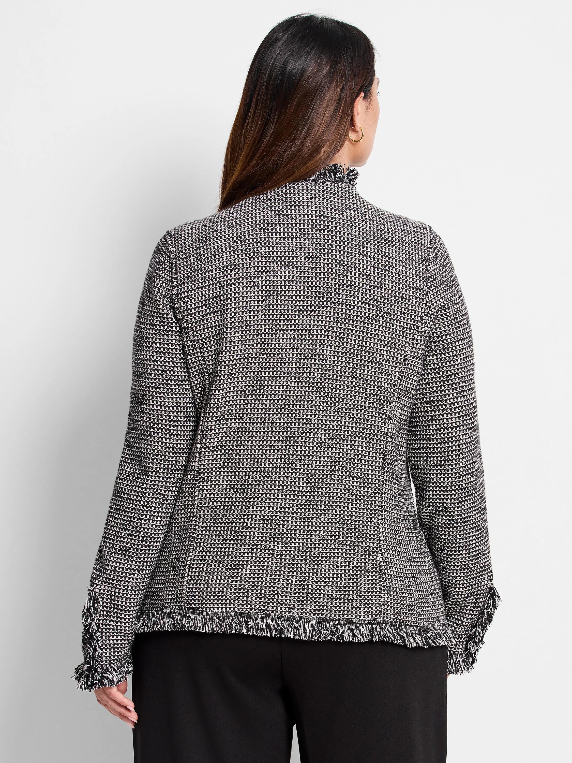 Black and white patterned knit jacket with a mock neck, fringed collar, cuffs, and hem.