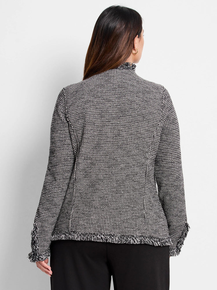 Black and white patterned knit jacket with a mock neck, fringed collar, cuffs, and hem.